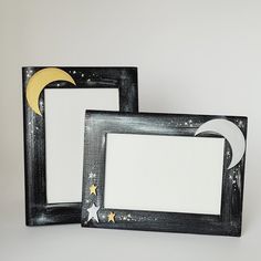 two black frames with stars and the moon painted on them