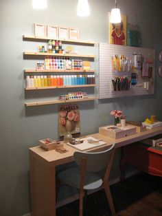 a craft room with two desks and shelves on the wall