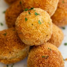 several small balls of food on a plate with parsley sprinkled on top