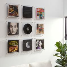 a white couch sitting in front of a wall mounted with various pictures on it's sides