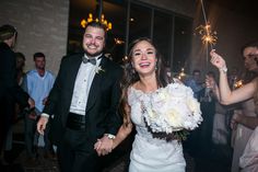 a bride and groom holding sparklers in their hands as they walk down the aisle