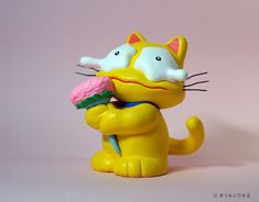 a yellow cat figurine holding an ice cream cone