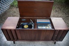 an old record player in a wooden case with vinyl records and tape recorders inside