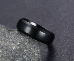 a black ring sitting on top of a rock