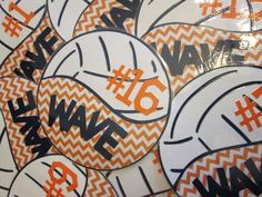 many orange and white volleyballs are on display