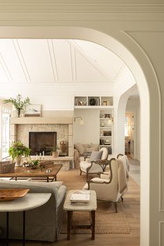 a living room filled with furniture and a fire place in the middle of a room