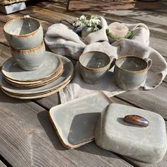 dishes and cups are sitting on a wooden table