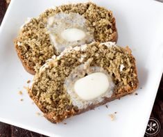 two muffins on a white plate with cream cheese in the middle and another muffin next to it