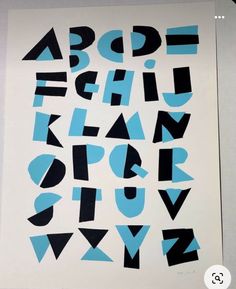 the letters are black and blue on white paper with numbers below them that appear to be cut out