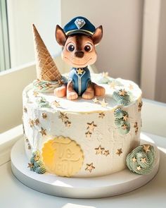 a cake decorated with an ice cream cone and dog figurine sitting on top