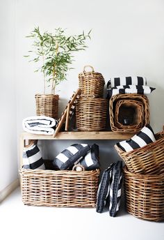 wicker baskets are stacked on top of each other in front of a white wall