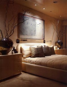 a large bed sitting in a bedroom next to a painting on the wall above it