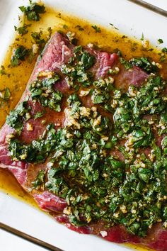 raw meat with herbs and seasoning on a white plate