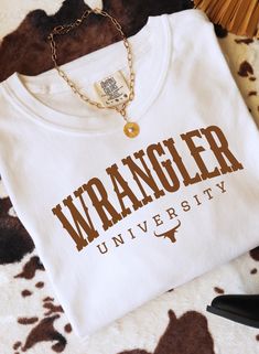 Wrangler Univeristy  Giddy up cowboy!! This western shirt will be an awesome addition to your wardrobe for all of the cowgirls.  Color: white  Choose between Gildan unisex soft style shirt  Comfort colors shirt  Gildan sweatshirt  Affordable prices for any budget!  Ships in 5 to 7 business days. Ships in a super cute bjt protective polymailer.  Please check sizing guide for the perfect fit!  No returns at this time, but if there is a problem please reach out for me to fix. Baby Clothes Country, Preppy Shirt, Western Tee, Western Wear Outfits, Western Boutique, Western Style Outfits, Western Tops, Gildan Sweatshirt, Wrangler Shirts