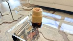 a glass table topped with a bottle filled with liquid