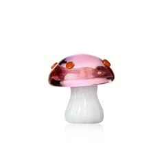 a pink and white glass mushroom sitting on top of a white countertop next to a wall