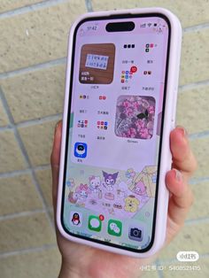 someone is holding up an iphone with stickers on it in front of a brick wall