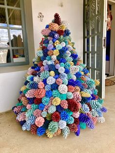 a colorful christmas tree made out of pine cones