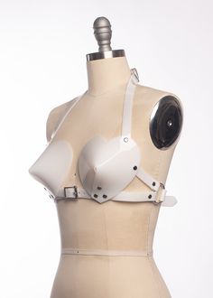 This bullet bra, or "cone bra" is inspired by retro pin-up vixens. This is the-heart-shaped version! Wear alone or layered and add a touch of drama to any outfit. Halter style straps. Buckles in front, back, and behind the neck. Silver-toned nickel plated hardware. Available in PVC, leather, and black vegan leather. Fits up to a DD cup - custom sizing available for larger cup sizes in leather, vegan leather, and clear PVC. Shown in white, clear, and red PVC (both translucent red and the new opaq Studied Leather Bra, Fire Pattern Bra, Bullet Bra, Retro Pin Up, All Things Cute, Choker Collar, Sheer Material, Cone Bra, Halter Style