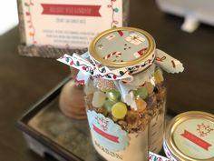 a jar filled with lots of candy sitting on top of a table next to a sign