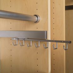 there is a coat rack with hooks on the wall next to some cupboards and shelves