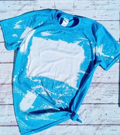 a blue t - shirt with white paint splattered on it