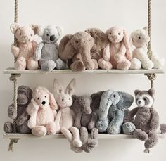 there are many stuffed animals hanging on the wall together, and one is pink or blue