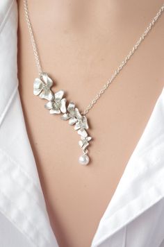 "Silver Necklace Orchid Necklace Flower lariat Necklace Flower Wedding Bridal Bridesmaid gifts Bridesmaid Jewelry Valentin gift The delicate, exotic and graceful orchid represents love, luxury, beauty and strength Feminine, elegant combination of silver and white swrovski Pearls. * Tarnish Resistant Silver Plated over Brass * 16mm(w) x 34mm(h) Necklace is 16 1/2 inches with Luster silver plated you may choose any length up to 20\". (NO EXTRA COST) Please leave a note at checkout to specify an al Delicate Silver Jewelry With Flower Decoration, Silver Flower Bridal Necklace For Wedding, Delicate Flower Wedding Jewelry, Dainty Flower Jewelry For Wedding, Dainty Flower-shaped Wedding Jewelry, Dainty Flower Wedding Jewelry, Silver Flower Necklace For Wedding, Flower-shaped Necklace With Flower Decoration For Wedding, Flower Shaped Necklace With Flower Decoration For Wedding