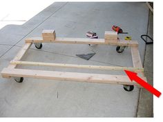 a wooden bed frame being assembled on the ground with tools and construction equipment around it