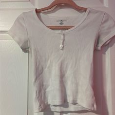 Never Worn Baby Tee. Great Condition And It's Very Soft. The Buttons Are Also In Perfect Condition. One Size. Cute Ribbed Cotton Tops, Cute Ribbed Tops, Tops Brandy Melville, Brandy Melville Tops, Baby Tee, Infant Tees, Brandy Melville, Brandy, Color White