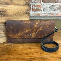 The Carly Clutch can be worn 5 ways - as a crossbody bag, a fanny pack, bum-bag, wallet or as a wristlet clutch. This small purse has a built-in wallet, with 3 card slots. The zippered pocket on the back will keep your small goods secure! 4.5" x 9" Single snap closure Removable 48" adjustable strap Removable wristlet One exterior zipper pocket Handcrafted in our workshop in Chariton, Iowa – USA Due to the resolution of your mobile and computer screens, actual color may vary. Our leather is premi Versatile Bifold Bag For Everyday Use, Classic Bags With Card Slots For Daily Use, Classic Bags With Card Slots For Everyday, Everyday Clutch Wallet On Chain With Mobile Phone Bag, Everyday Use Satchel Wallet With Card Slots, Satchel Wallet With Card Slots For Everyday Use, Travel Wallets With Cell Phone Pocket In Satchel Shape, Everyday Wallet On Chain With Mobile Phone Bag, Travel Wallet With Mobile Phone Bag Satchel Shape