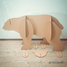 an animal made out of cardboard sitting on top of a wooden floor