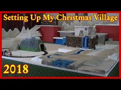 the setting up my christmas village is being displayed in front of a red sign that says set up my christmas village