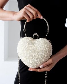 Who doesn't want to go out at night with a stylish bag in hand? This beautiful bag, designed with pearls and representing your heart, will leave you in awe.❤️ It is heart shaped, covered with imitation pearl stones. You can use it as a hand and arm bag. You can either carry it in your hand or hang it on your arm with its long chain. Length :19 cms ( 7.48 inches )   width :   20 cm ( 7.87 inches ) You can buy it as a gift for yourself or your loved ones. An elegant bag that you will love to use i Luxury Heart-shaped Party Shoulder Bag, Elegant Heart-shaped Evening Bag Gift Idea, Elegant Heart-shaped Evening Bag For Gifts, Pearl White Handheld Bags For Party, Handheld Pearl Shoulder Bag For Parties, Heart-shaped Evening Bag For Wedding, Elegant Heart-shaped Evening Bag, Elegant Heart-shaped Evening Bag For Events, Elegant Heart-shaped Evening Bag For Formal Occasions