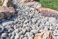 a rock garden with grass and rocks in the background