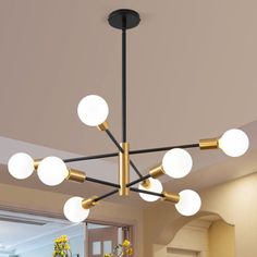 The 8-light Sputnik Chandelier is a spectacularly versatile piece that complements many different decor styles. Mid-century Brushed Brass finish pairs perfectly to elevate this industrial pendant to luxury. The exposed bulbs bring an air of nostalgia for an older, more refined time. Perfect for a dining room, living room, bedroom, foyer, hallway, and bar. Warm Reminder: The white Globe is the bulb, and the product does not include the bulb. Corrigan Studio® Finish: Black/Gold | Corrigan Studio® Sphere Chandelier, Foyer Hallway, Angled Ceilings, Tiered Chandelier, Chandelier Black, Wheel Chandelier, Bedroom Foyer, Black Spray Paint, Electric Company