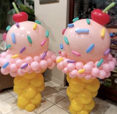 two giant balloons with sprinkles and cherry on top are shown in front of a doorway