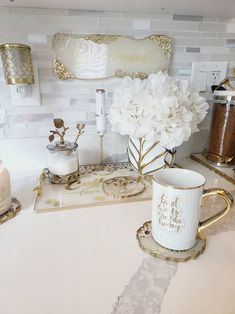 there is a coffee cup on the counter next to some candles and other items in front of it