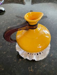 a yellow vase sitting on top of a table