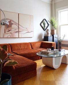 a living room filled with furniture and a large painting on the wall above it's coffee table