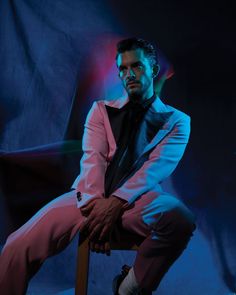 a man in a suit and tie sitting on a chair