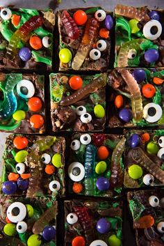 several square trays filled with different types of candy and eyeballs on top of each other