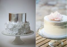 two different cakes with white frosting and pink flowers on each cake stand, one has a single flower on top