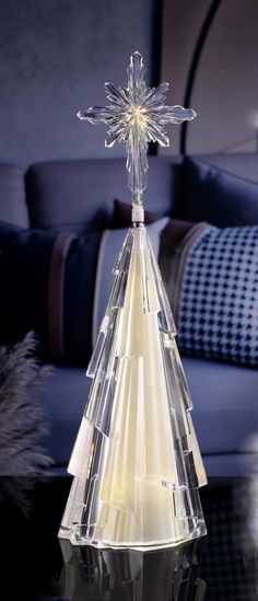 a clear glass christmas tree on a table