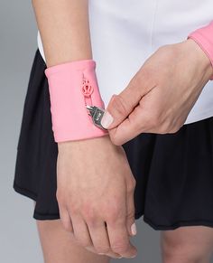 a woman wearing a pink wristband with the word love written on it, and holding onto her arm