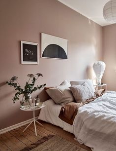 a bed sitting in a bedroom next to a wall with pictures hanging on it's side