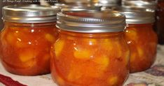 four jars filled with food sitting on top of a table