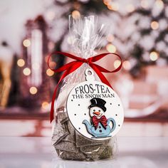 a bag of frosted tea with a snowman tag on it sitting on a table