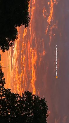 the sky is filled with orange clouds as the sun sets in the distance behind them