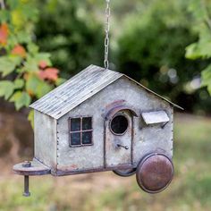 a metal birdhouse hanging from a chain